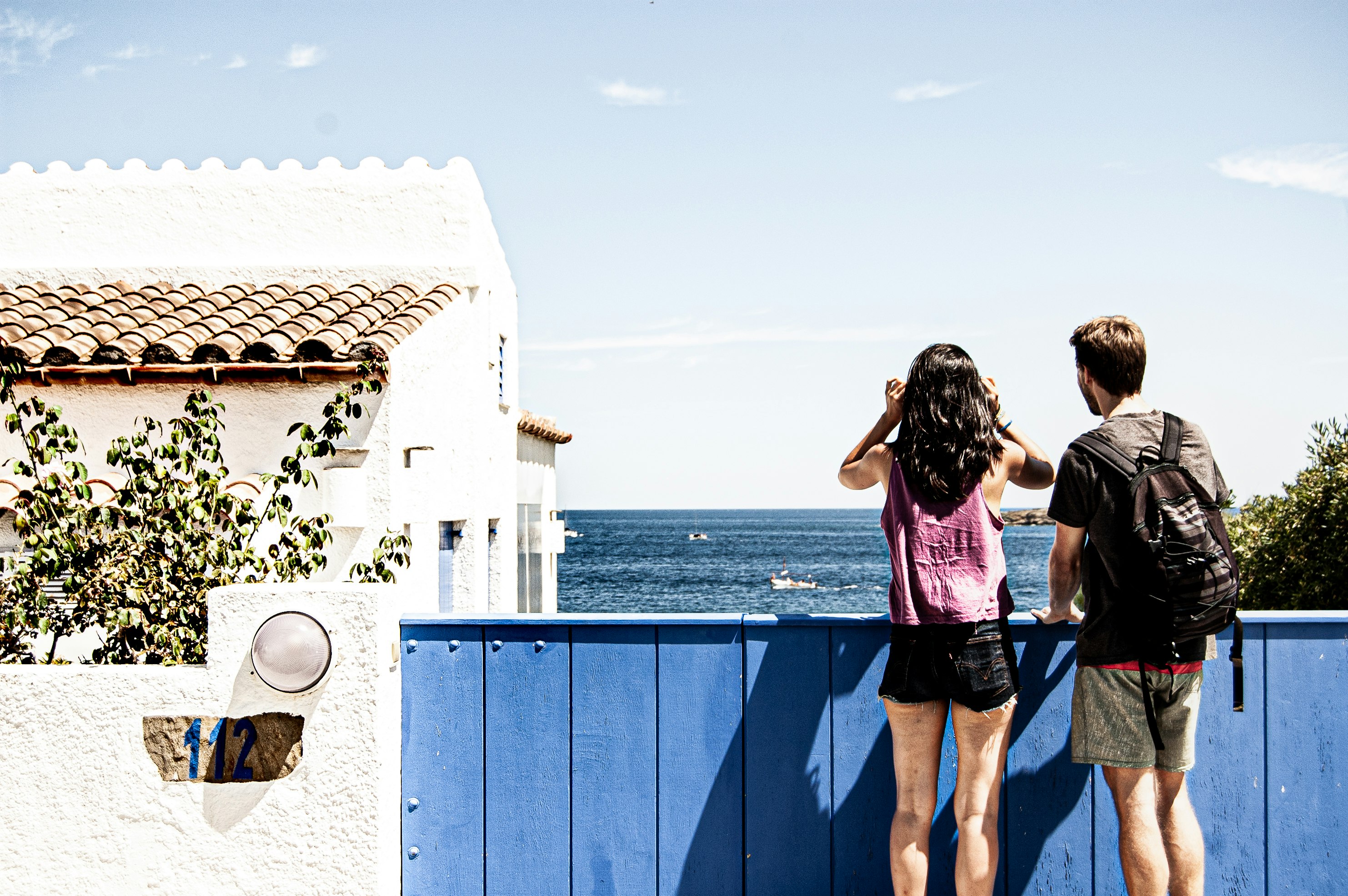 woman in pink and black tank top and blue denim shorts standing on blue metal railings